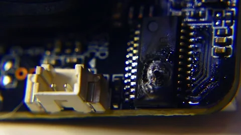 A microchip on an intricate circuit board is burnt due to over-voltage Stock Footage 289824415