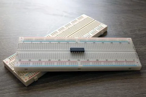 Microchip on a stacked breadboard for electrical engineering on a table Stock Photos