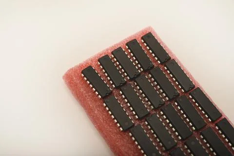 Microchips on red foam. Chip packaging. Microchips in a DIP package. Stock Photos