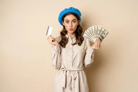 Microcredit and money concept. Young stylish woman showing credit card and Stock Photos