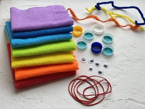 Microfiber cloth multi-colored and plastic lids and elastic bands, for kids DIY. Stock Photos