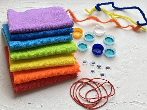 Microfiber cloth multi-colored and plastic lids and elastic bands, for kids DIY. Stock Photos