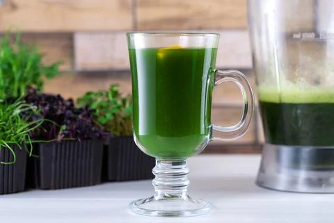 Microgreen juice on the kitchen table. Micro greens in a blender. Make a micr Stock Photos