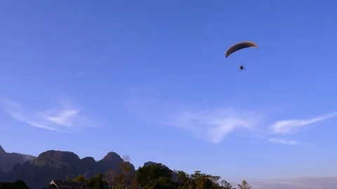 Microlight parachute powered by a motor is flying over the Nam Song river Video stock 102294824