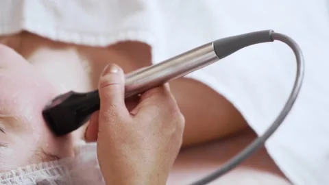 The microneedle radiofrequency lifting device in the doctor's hand works with Stock Footage 190048982