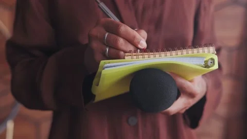 Microphone and notepad for interviewing in hands woman journalist close up Stock Footage 213305591