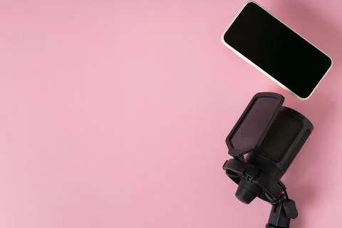 Microphone and smartphone on a pink background with a space for text. Stock Photos