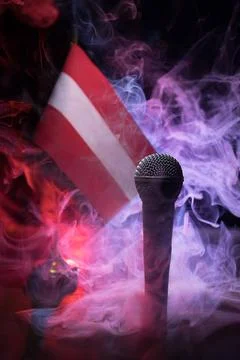 Microphone on a background of a blurry flag of Austria close-up. dark table d 스톡 사진