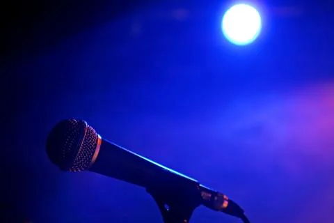 Microphone close up with blue light on background Stock Photos