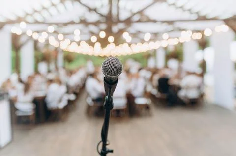 Microphone close-up. Focus on mic. Abstract blurred conference hall or weddin Stock Photos