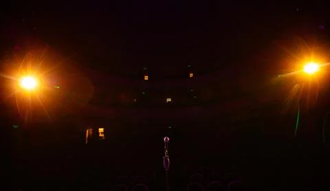 Microphone on the empty stage with spotlights Stock Photos