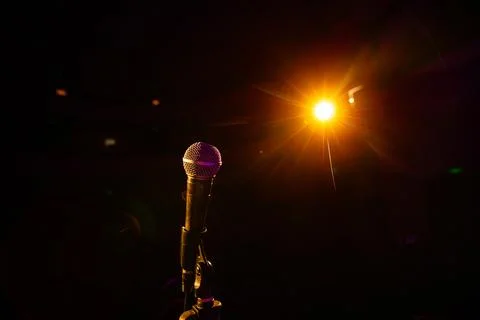 Microphone on the empty stage with spotlights Stock Photos