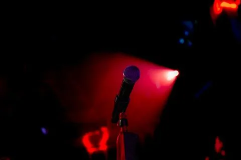 Microphone on the empty stage with spotlights Stock Photos