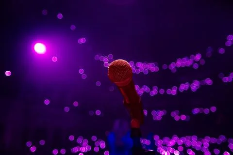 Microphone on the empty stage with spotlights Stock Photos