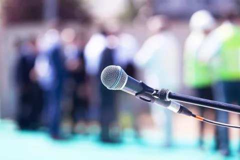 Microphone in focus against blurred group of people Foto stock