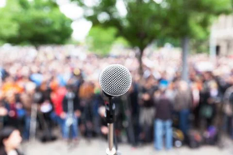 Microphone in focus against blurred protest or public demonstration Stock Photos