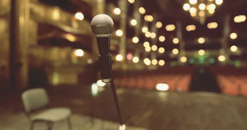 Microphone in focus on stage with blurred audience in background Stock Footage 310826537