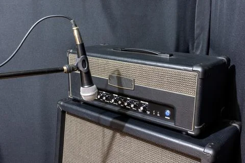 A microphone in front of a guitar amplifier Stock Photos
