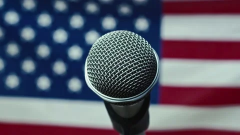 A Microphone In Front Of A Slow Motion USA Flag Ready For A Public Address From Stock Footage 155619233