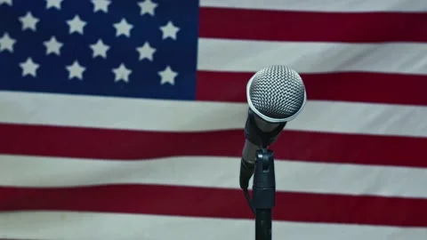 A Microphone In Front Of A Slow Motion USA Flag Ready For A Public Address From Stock-Footage 155753920