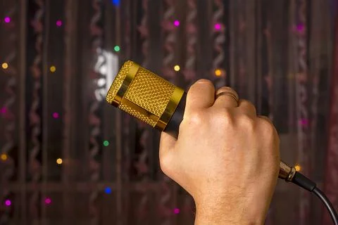 Microphone in hand. Interview. Karaoke. A man's hand holds a microphone again Stock Photos