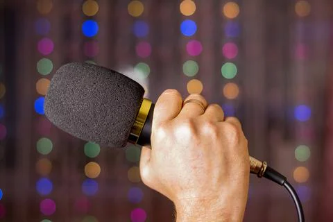 Microphone in hand. Interview. Karaoke. A man's hand holds a microphone again Stock Photos