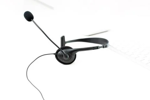 Microphone headset on white table with blur computer keyboard background Stock Photos