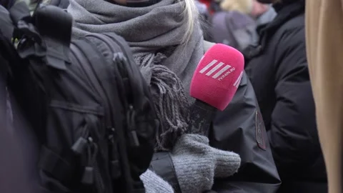 Microphone with the logo of Silver Rain TV channel in reporter's hand Video stock 125556637