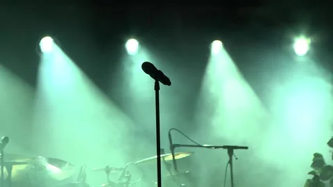 Microphone mounted on a stage of performances illuminated by green spotlight Stock Footage 145664022