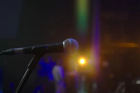 A microphone is pointed at a bright light. The microphone is black and silv.. Stock Photos