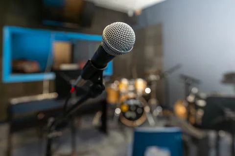 Microphone in a recording studio with a blurred background including a drum kit. 写真素材