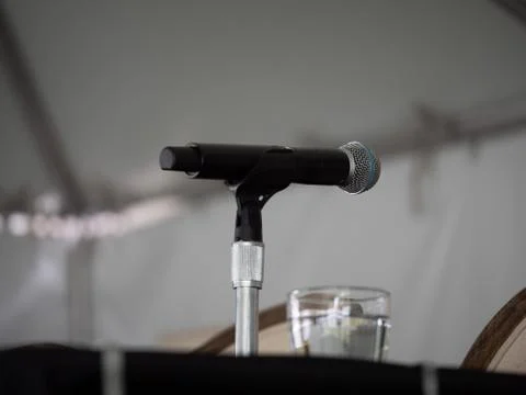 Microphone sitting on presenters table waiting for speaker Stock Photos