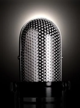Microphone spotlighted on a black background. Stock Photos