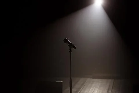 Microphone on the stage with black background Stock Photos