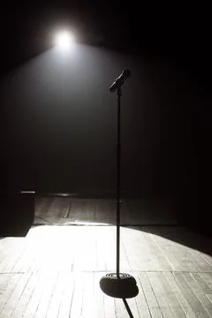 Microphone on the stage with black background Stock Photos