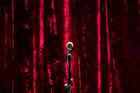 A microphone on stage over a red background. 写真素材