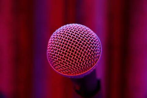 Microphone on stage in red-blue light. Stock Photos
