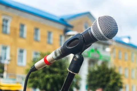 Microphone on a stand building in the background Stock Photos