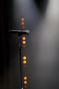 Microphone on the stand on the stage backlight dark background Foto stock