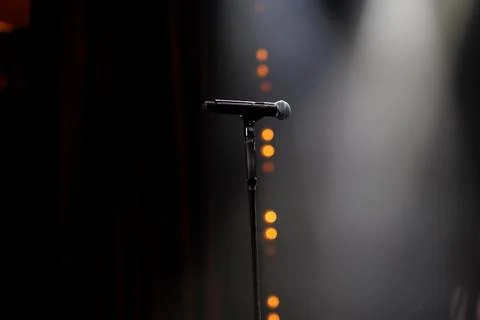 Microphone on the stand on the stage backlight dark background Foto stock