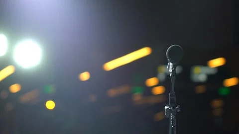 Microphone on stand on stage of bokeh of lights on background, auditorium, close Stock Footage 105216675