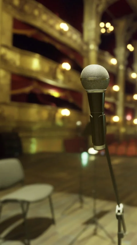 Microphone stands in theater preparing for upcoming performance at night Stock Footage 331443353