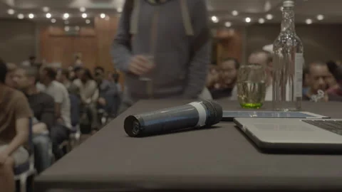Microphone on table with audience in background at a conference Stock Footage 342565575
