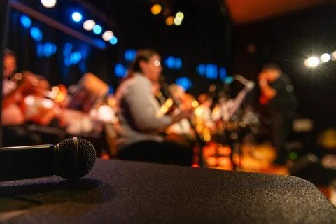 A microphone is on a table in front of a crowd Foto stock