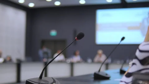Microphone is on a table in front of a large screen Stock Footage 312968939