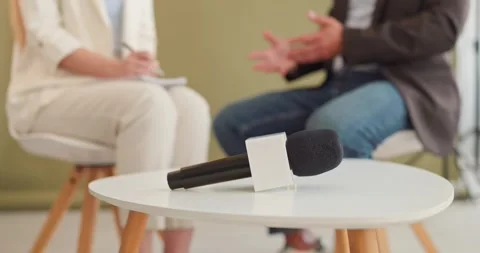 Microphone on table with journalist and guest during studio interview setup Stock Footage 346418265