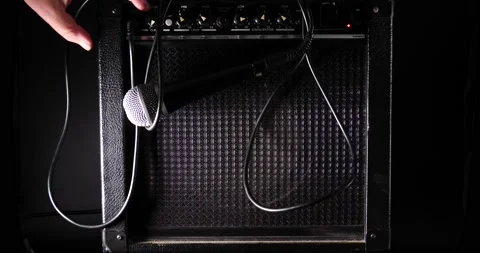 Microphone wires tangled up on amplifier turn on and plugged in close up Stock Footage 204959836
