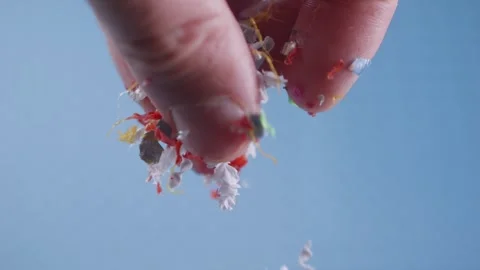 Microplastic particles cascade from fingers in slow motion, representing en.. Stock Footage 291096077