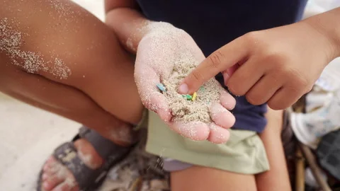 Microplastic pollution on beach environment, single-use plastic in sand Stock Footage 306723270