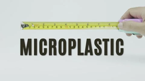 Microplastic text or word and tape measure on a white background Vídeo Stock 302088895